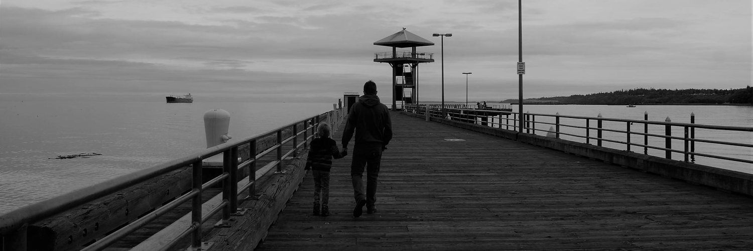Chad and his son walking along a pier